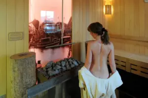 A woman in a sauna looking at a picture of a boat.